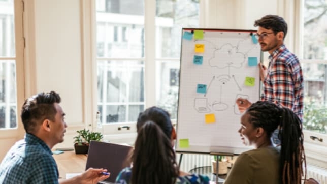 un groupe de personnes travaillant sur un tableau blanc