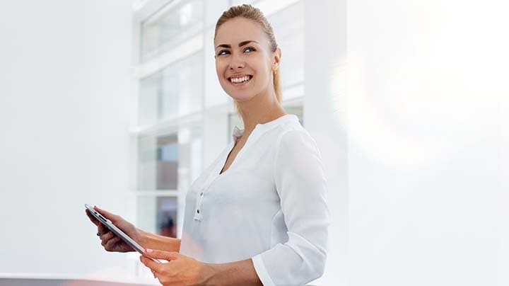 Mulher sorridente segurando um tablet