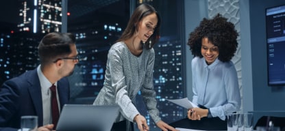 People in a corporate office meeting reviewing a report